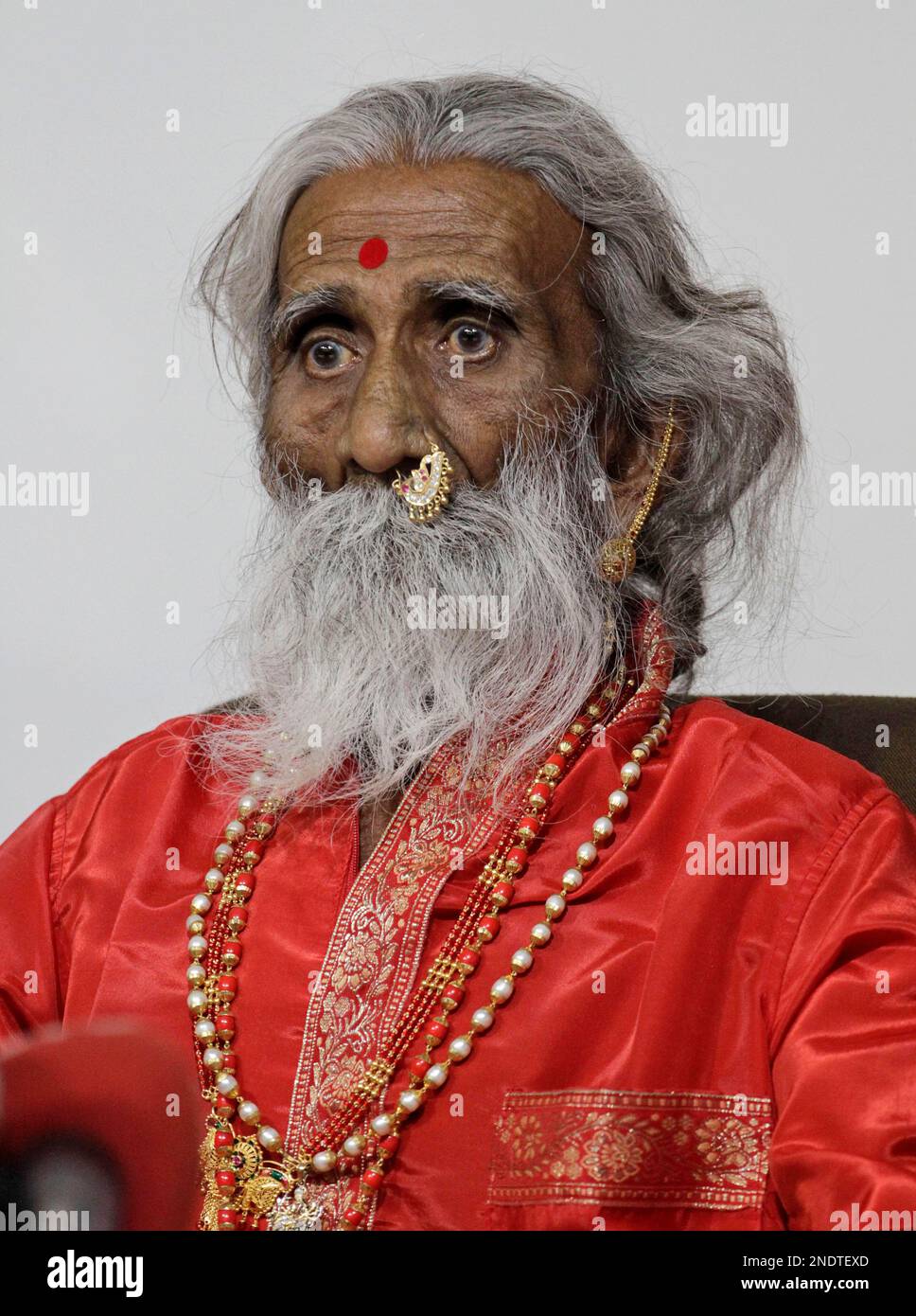 Indian sadhu, or Hindu holy man, Prahlad Jani looks on during an interaction with the press at a hospital in Ahmadabad, India, Thursday, May 6, 2010. Jani, 82, claims to have spent seven decades surviving without food and water and not passing urine and stool and is currently under observation by Indian military scientists and doctors in a private hospital. (AP Photo/Ajit Solanki) Stock Photo