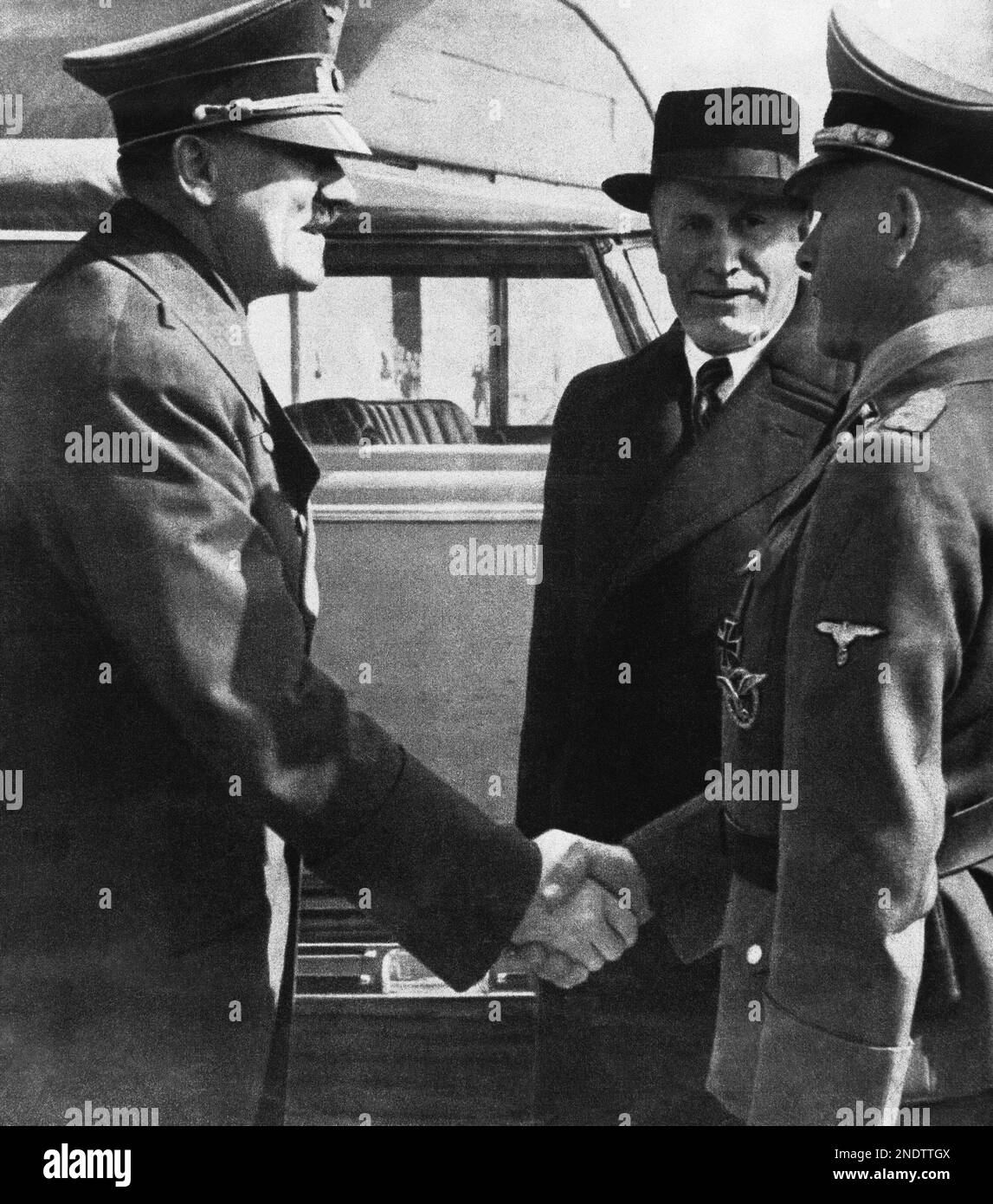 Italian dictator Benito Mussolini, centre, wearing black hat and coat