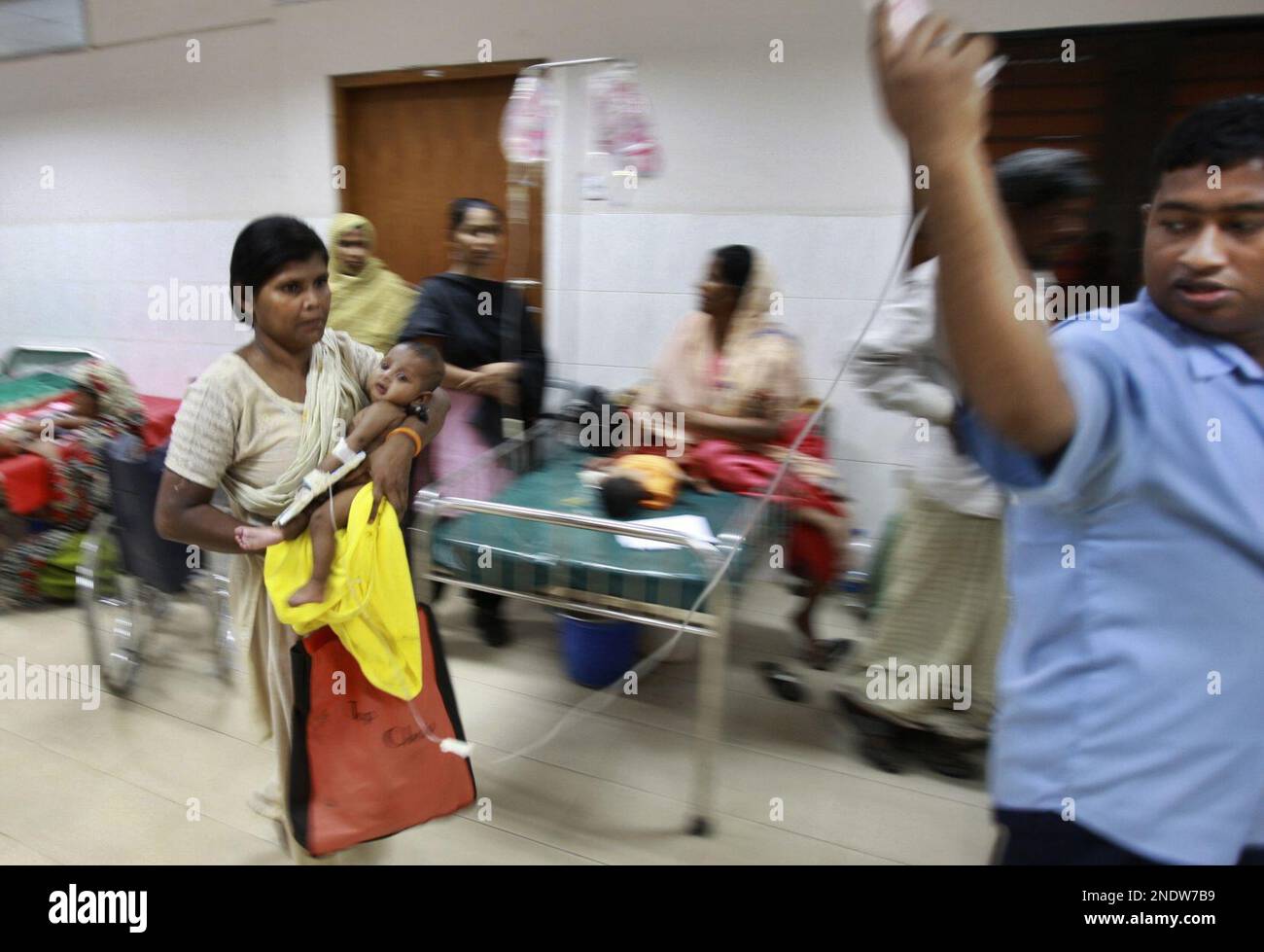 In this April 6, 2010 photograph, a Bangladeshi woman rushes a child for treatment at the
