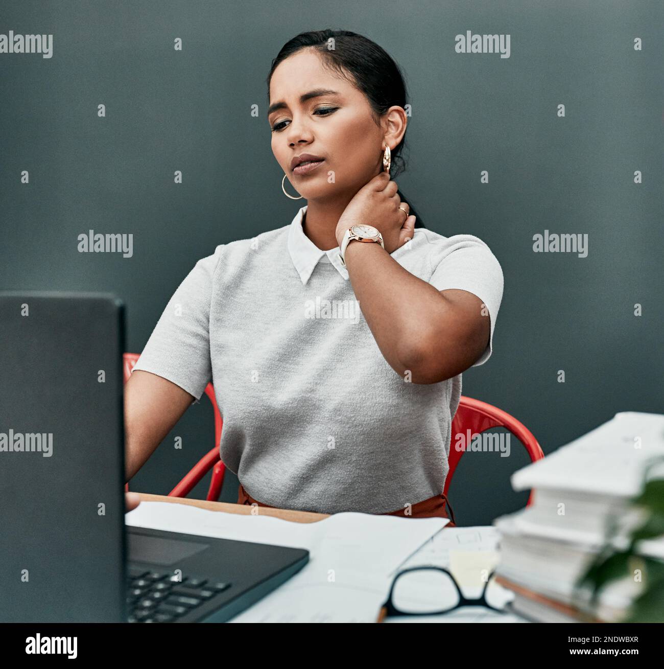 Working at a desk is a common cause of back and neck pain. a young