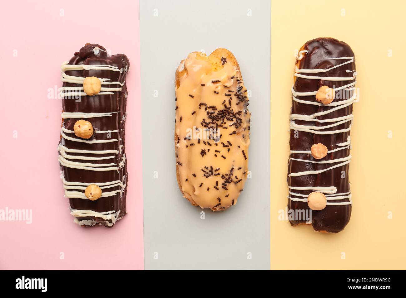 Tasty glazed eclairs on colorful background Stock Photo