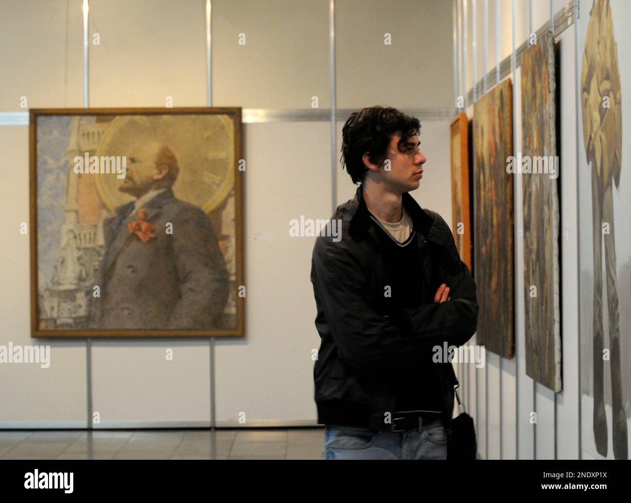 A visitor looks at the Soviet-era paintings that depict Vladimir Lenin ...