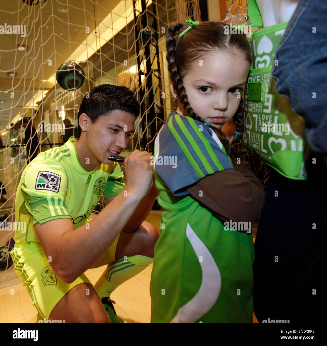 Seattle Sounders MLS soccer player Fredy Montero, of Colombia, signs the  jersey of Angelina Lucero, 4, at an event debuting the team's new "third  kit" uniforms, Tuesday, April 20, 2010, at the