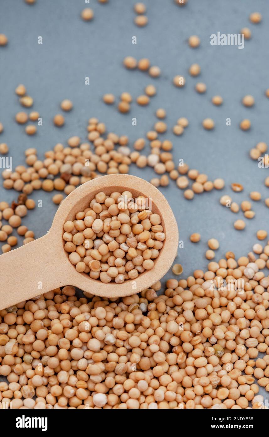 Yellow mustard seeds with scoop on mottled grey surface Stock Photo Alamy