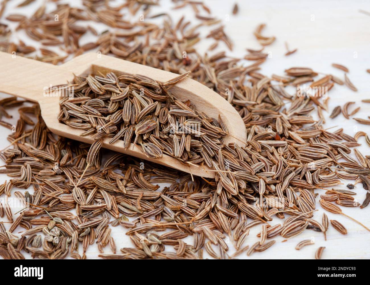 Caraway or Cumin seeds close up with selective focus in wooden scoop Stock Photo