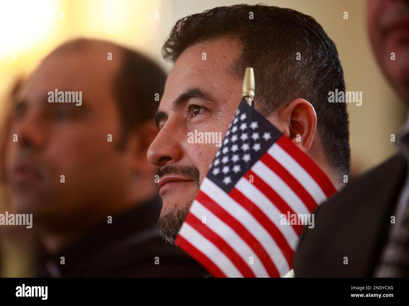 Antonio Gomez, originally from El Salvador, holds an American flag