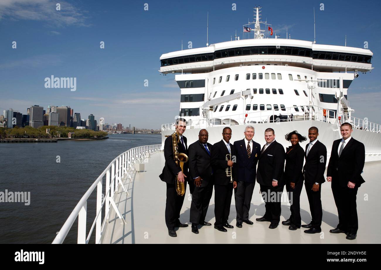 Queen mary 2 entertainment director ray rouse center poses with