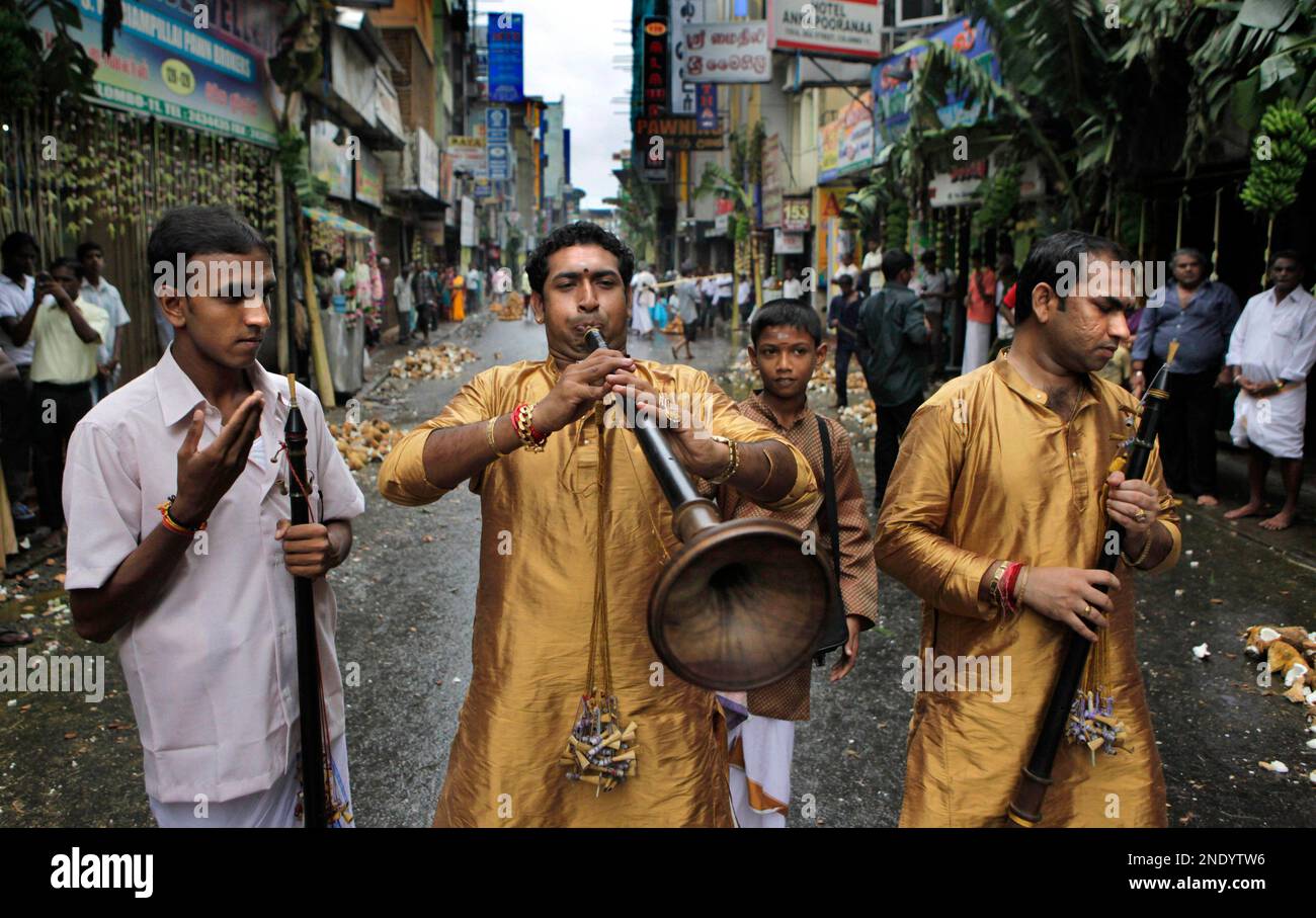Sri Lankan Tamils play musical instruments and participate in a religious chariot procession