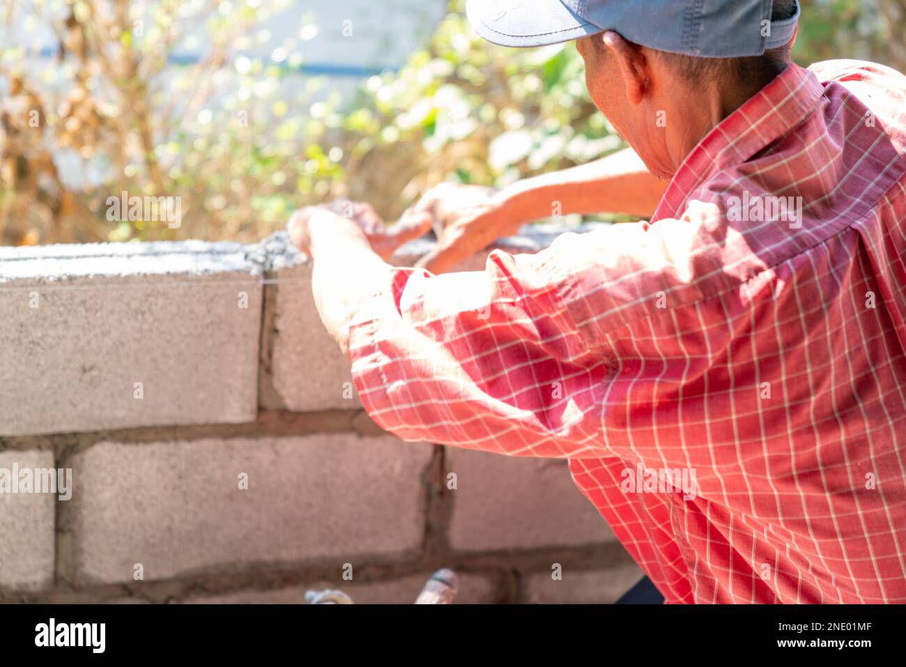 Manson or Brick builders are building walls in construction site Stock