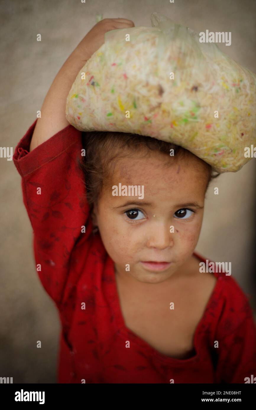 Imam Rice A Pakistani child carries a bag of donated rice from a food ...