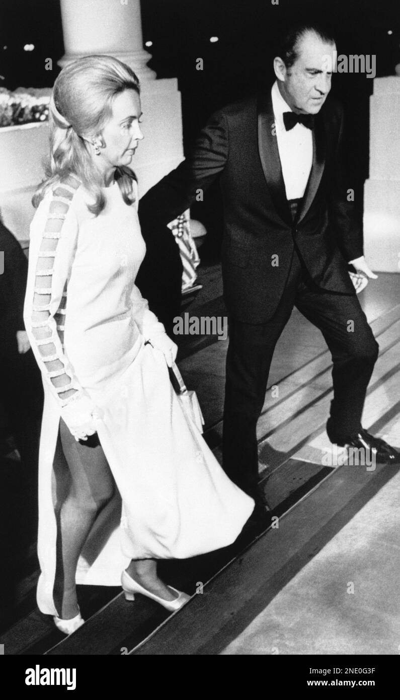 Wearing a doublesplit white evening gown, Sonia McMahon, wife of