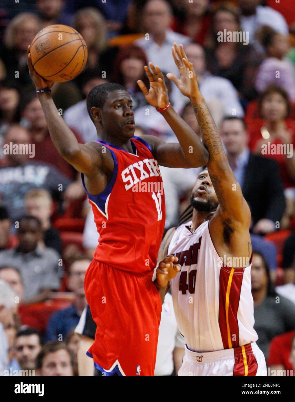 Philadelphia 76ers guard Jrue Holiday, left, passes past Miami Heat forward Udonis Haslem during