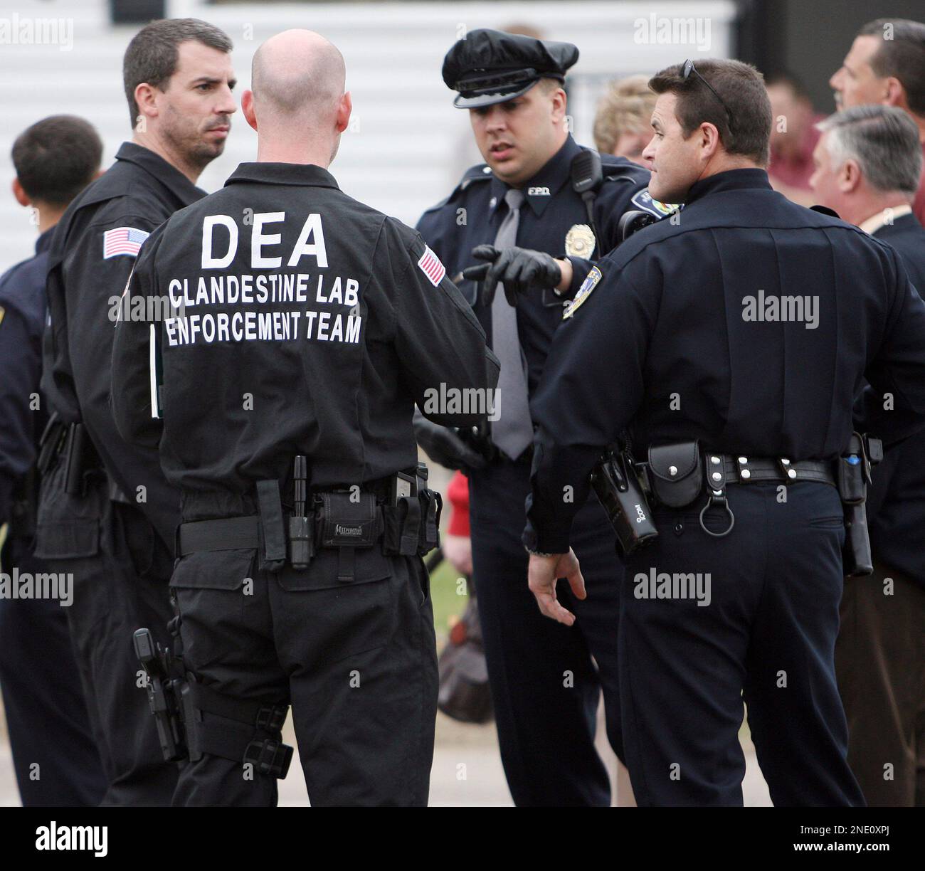 State and federal law enforcement officers are seen outside a house
