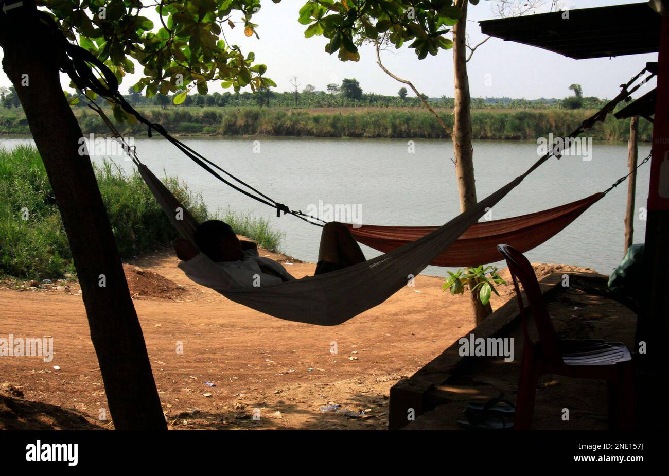 A Cambodian man sleeps on an hammock lnear the Mekong River bank at ...