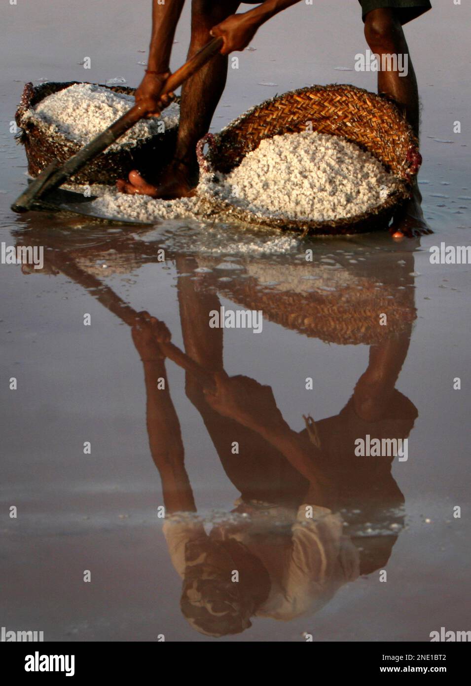Pakistani laborer Aslam Baloch rakes up seasalt in Karachi, Pakistan