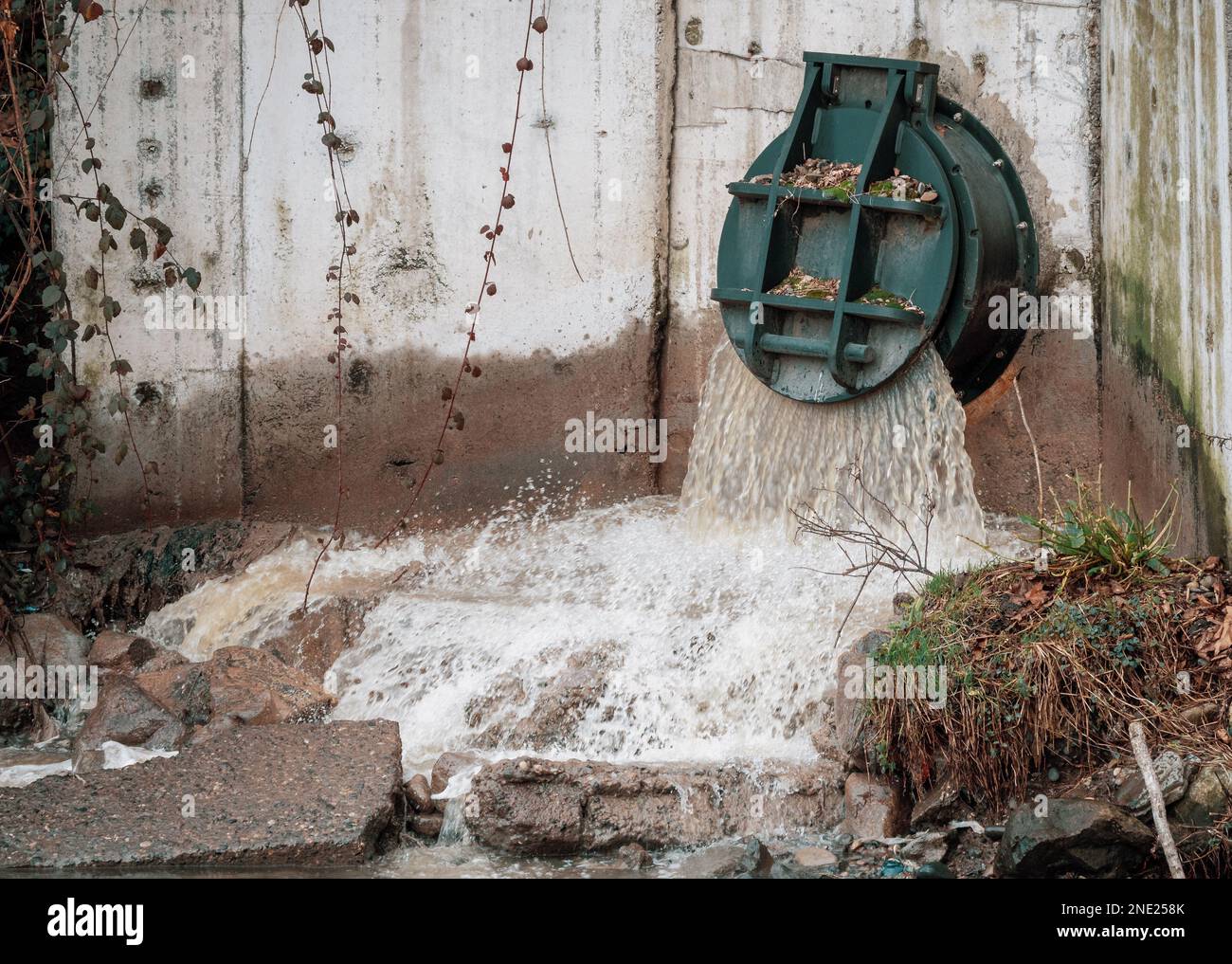 Rainwater outflows through flood drainage system, Water runoff from road spillway to sewage