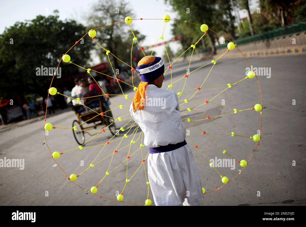 An Indian Sikh swings a plastic rope weapon called a chakkar during a
