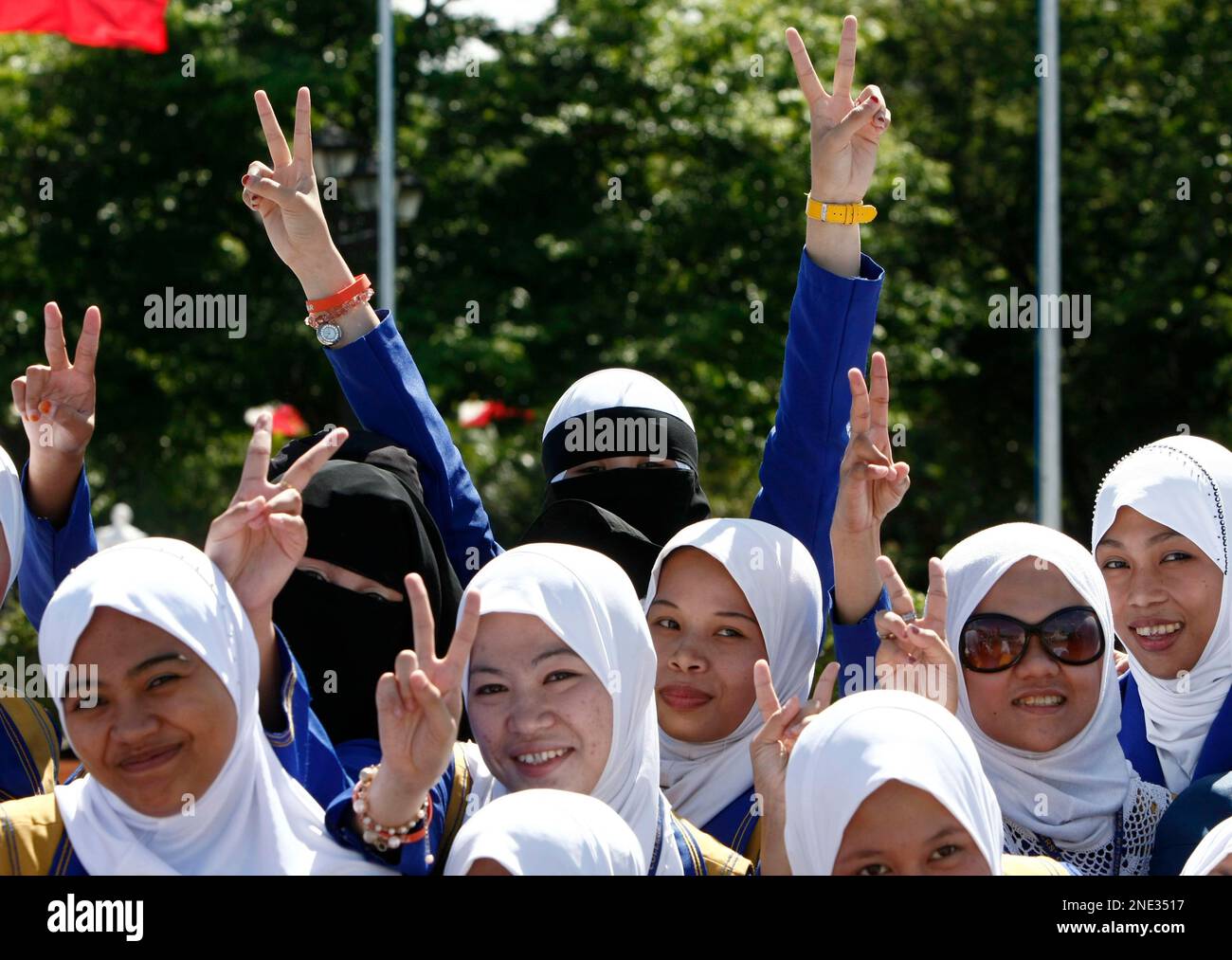 Filipino Muslim students from the Philippine Muslim Teachers College in Marawi in southern Philippines, flash the peace sign as they pose in front of the monument of the Philippines' national hero Dr. Jose P. Rizal Tuesday, March 23, 2010 in Manila, Philippines. The students are in Manila for an educational tour with professor Agakhan Mangondato Sharief (unseen) who campaigned for a provincial board seat as "Osama Binladen" but lost in Lanao province in southern Philippines in 2007. (AP Photo/Bullit Marquez) Stock Photo
