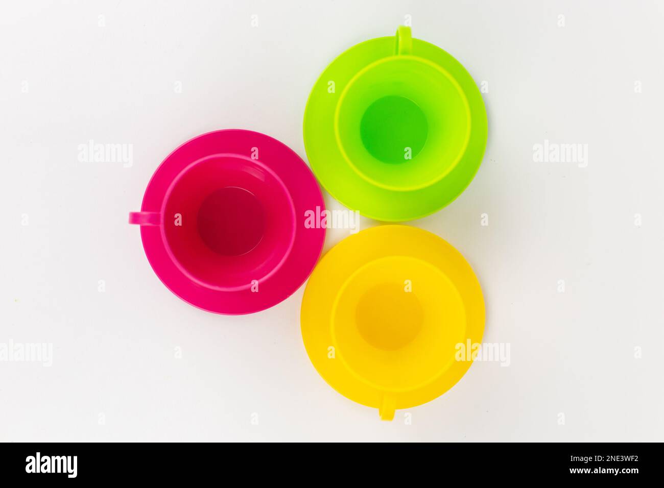 a multi-colored plastic cups and plates on a white background kitchen set Stock Photo