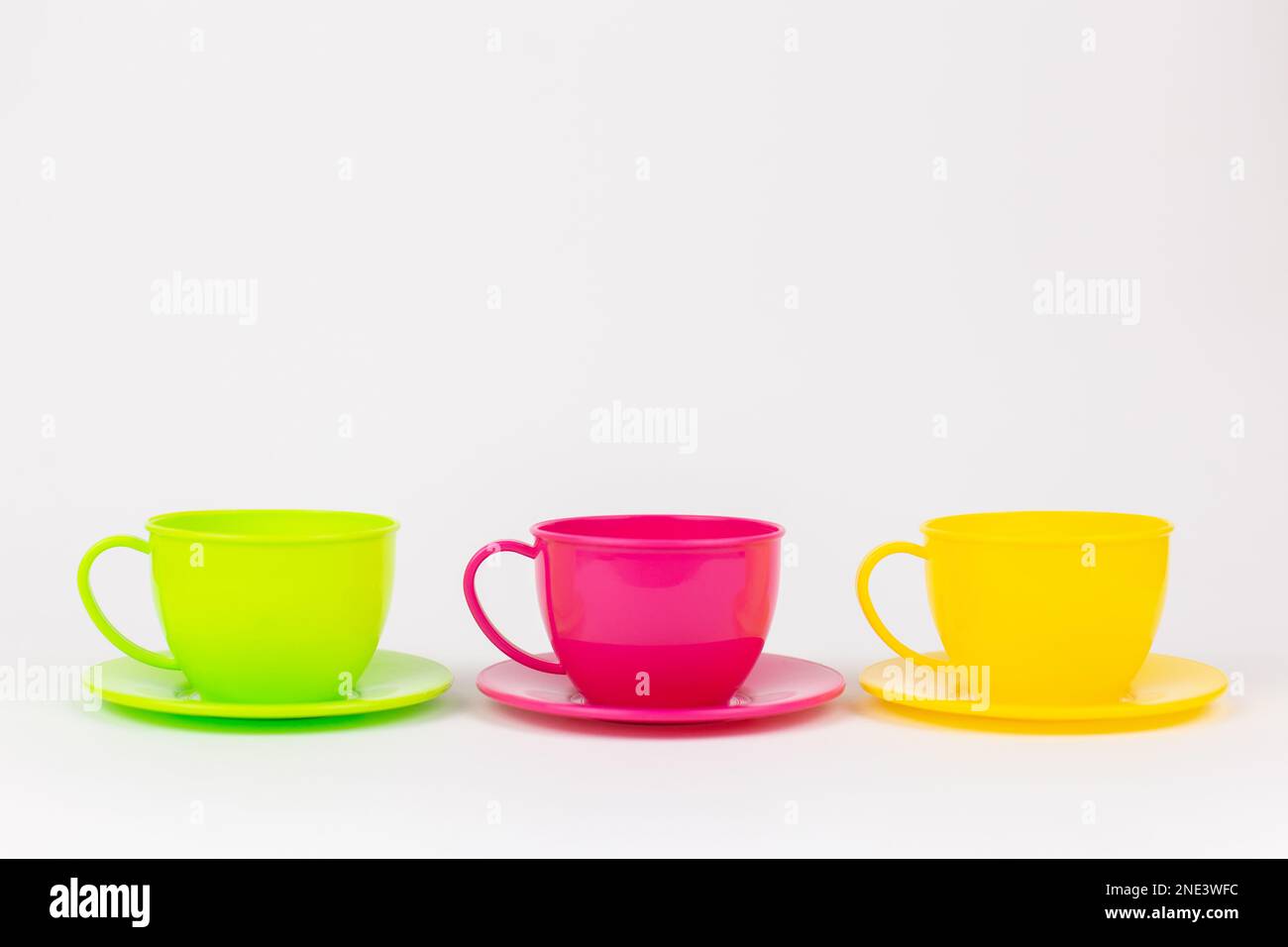 a multi-colored plastic cups and plates on a white background kitchen set Stock Photo