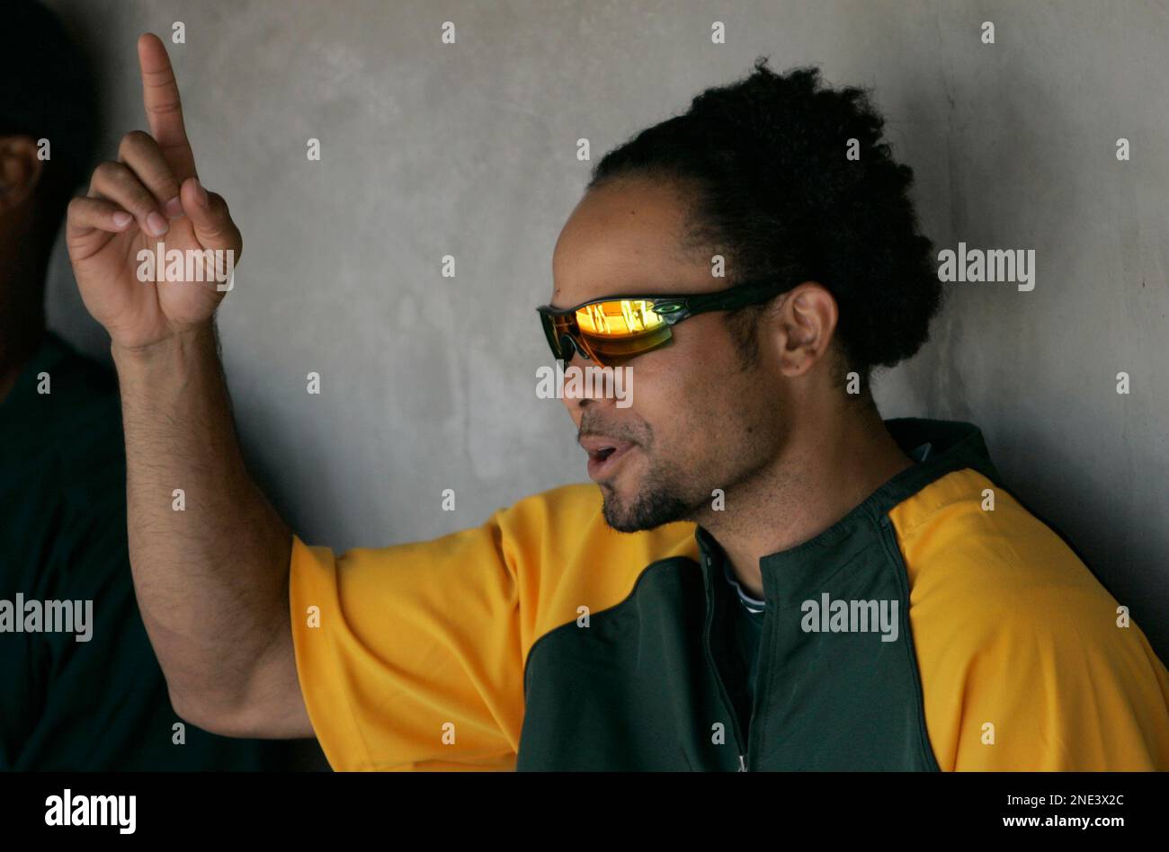 Oakland Athletics' Coco Crisp sits in the dugout as he shows off his hair  before action against the Detroit Tigers at Oakland-Alameda County Coliseum  in Oakland, California, on Thursday, April 14, 2011. (