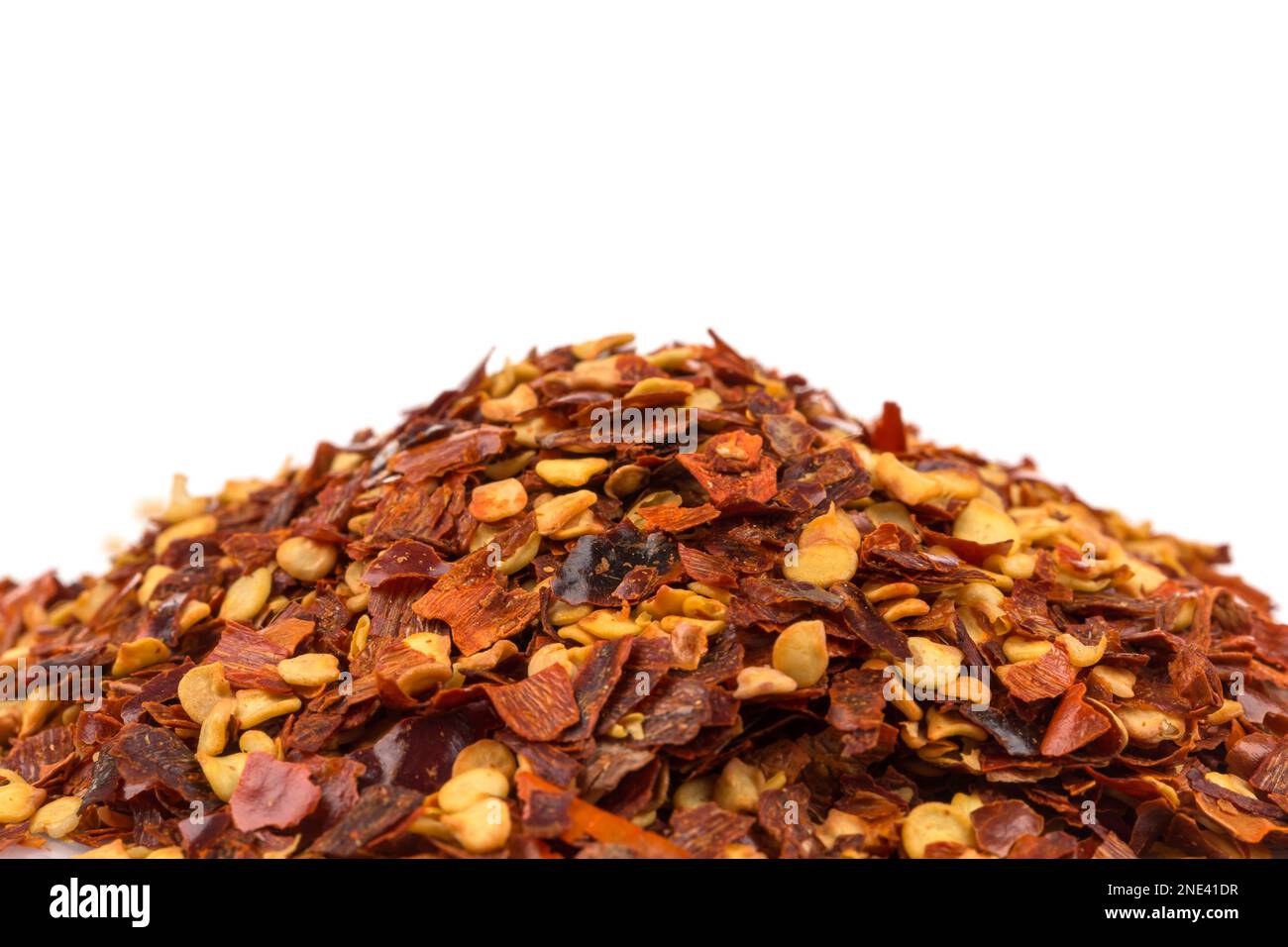 The pile of a crushed red pepper, dried chili flakes and seeds isolated