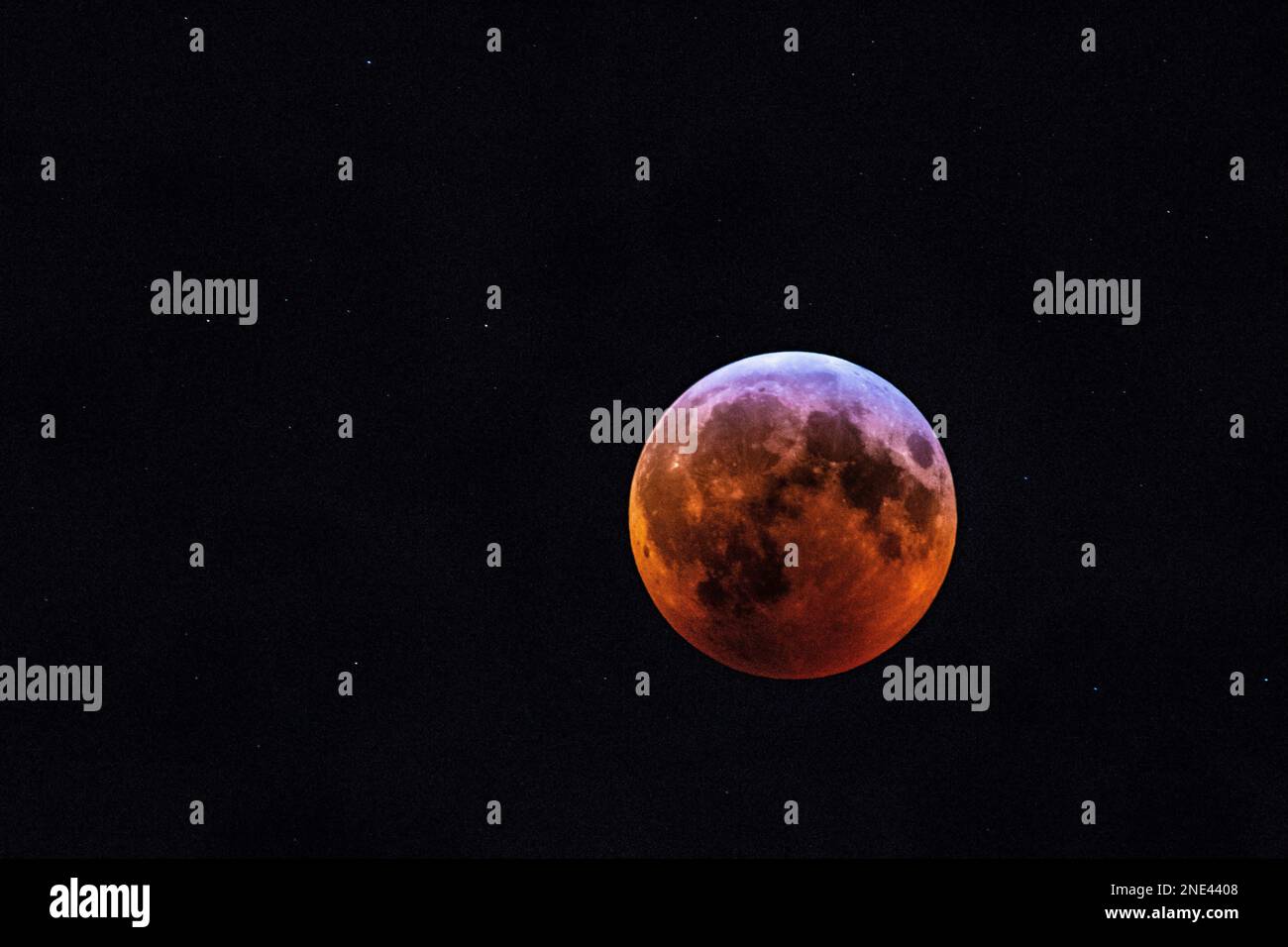 This image features a breathtaking view of a lunar eclipse, with the blood moon in full view Stock Photo