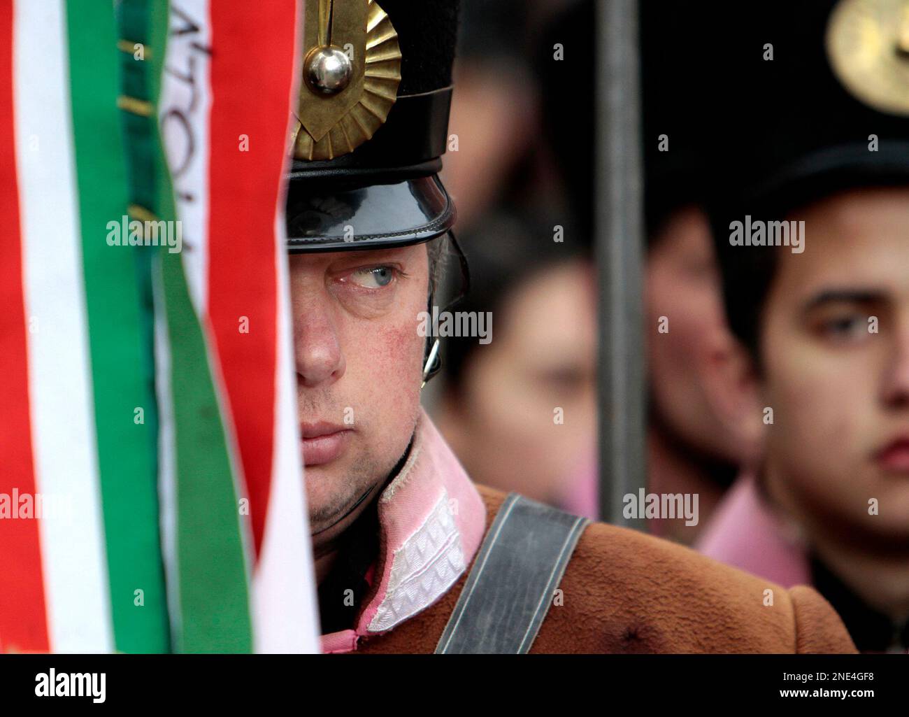An Ethnic Hungarian man wearing a vintage military uniform seen from behind a flag during celebrations of the anniversary of the 1848 revolution against the Hapsburgs, in Targu Secuiesc, Romania, 250 kilometers north of Bucharest, Monday, March 15, 2010. Thousands of ethnic Hungarians gathered in towns across Romania's Transylvanian region to celebrate the Hungarian holiday. (AP Photo/Vadim Ghirda) Stock Photo