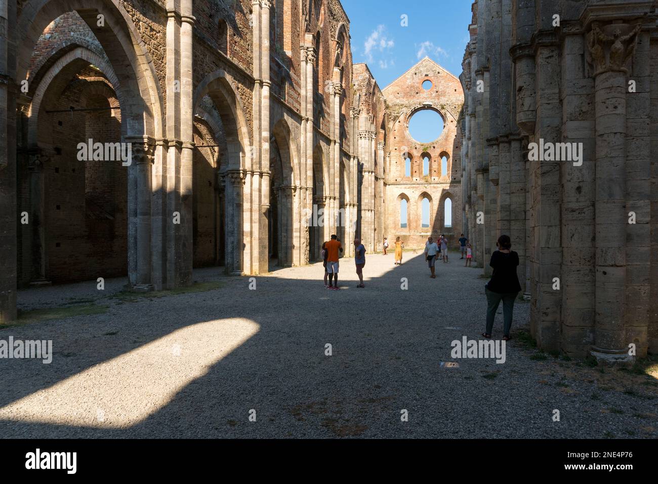 San Galgano ,Italy-august 8,2020:Tourists visit the interior of the abbey and former monastery of San Galgano famous for being roofless during a sunny Stock Photo