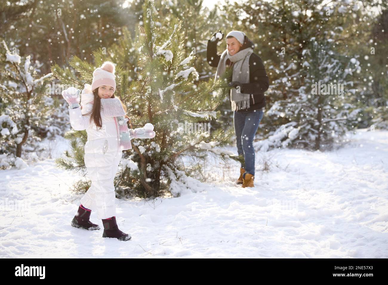Father and daughter having snowball fight outdoors on winter day. Christmas vacation Stock Photo