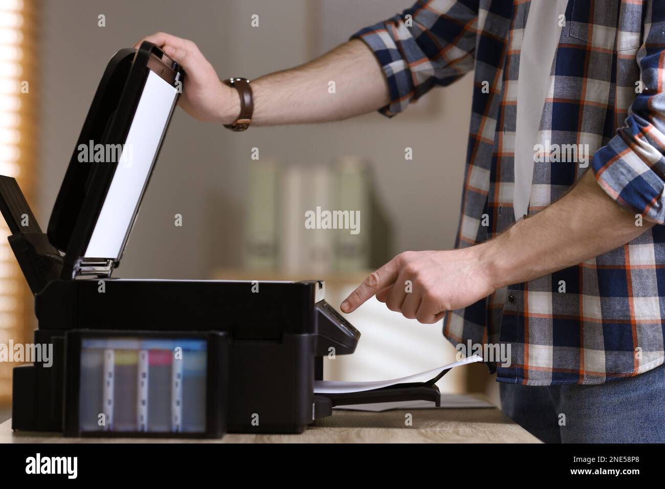 Man using modern multifunction printer in office, closeup Stock Photo ...
