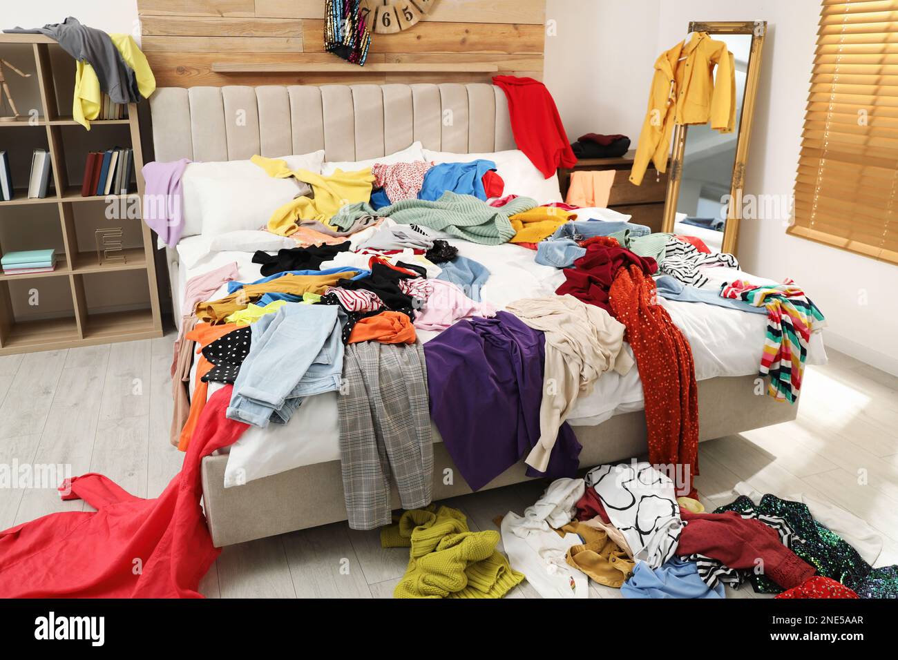Pile of clothes on bed in messy room. Fast fashion concept Stock Photo