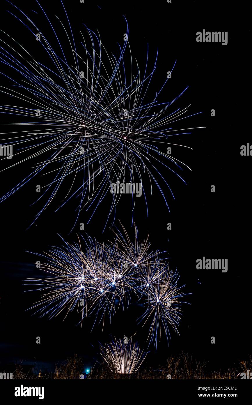 Vertical image of a fireworks display with wind affecting the