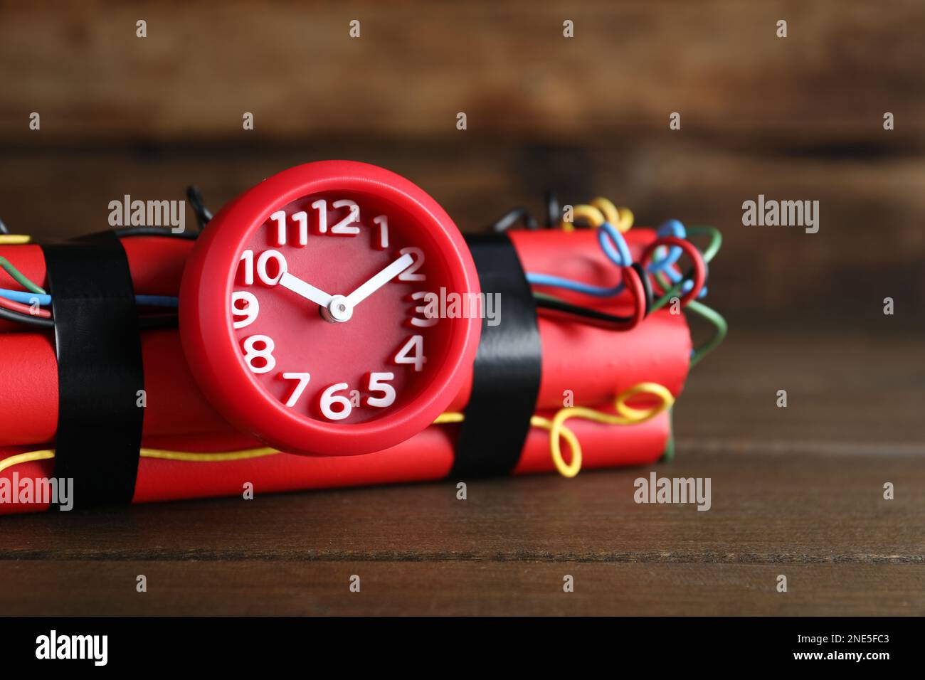 Dynamite time bomb on wooden table, closeup Stock Photo