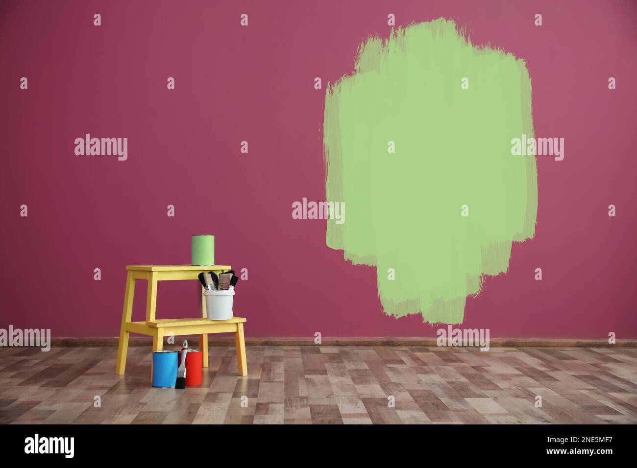 Set with decorator's tools and paint on floor near color wall Stock