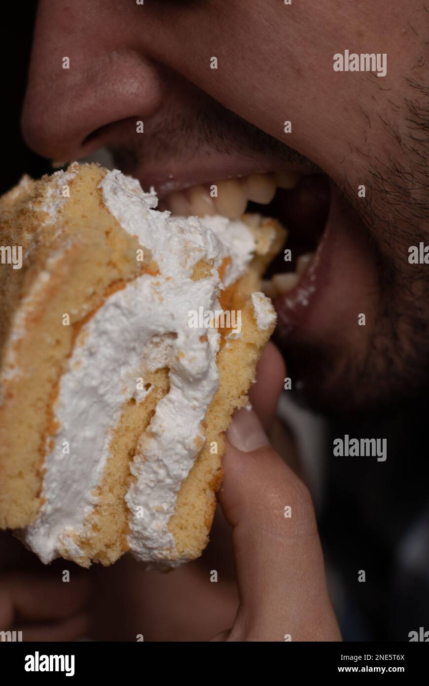 Man is biting piece of lemon cake Stock Photo