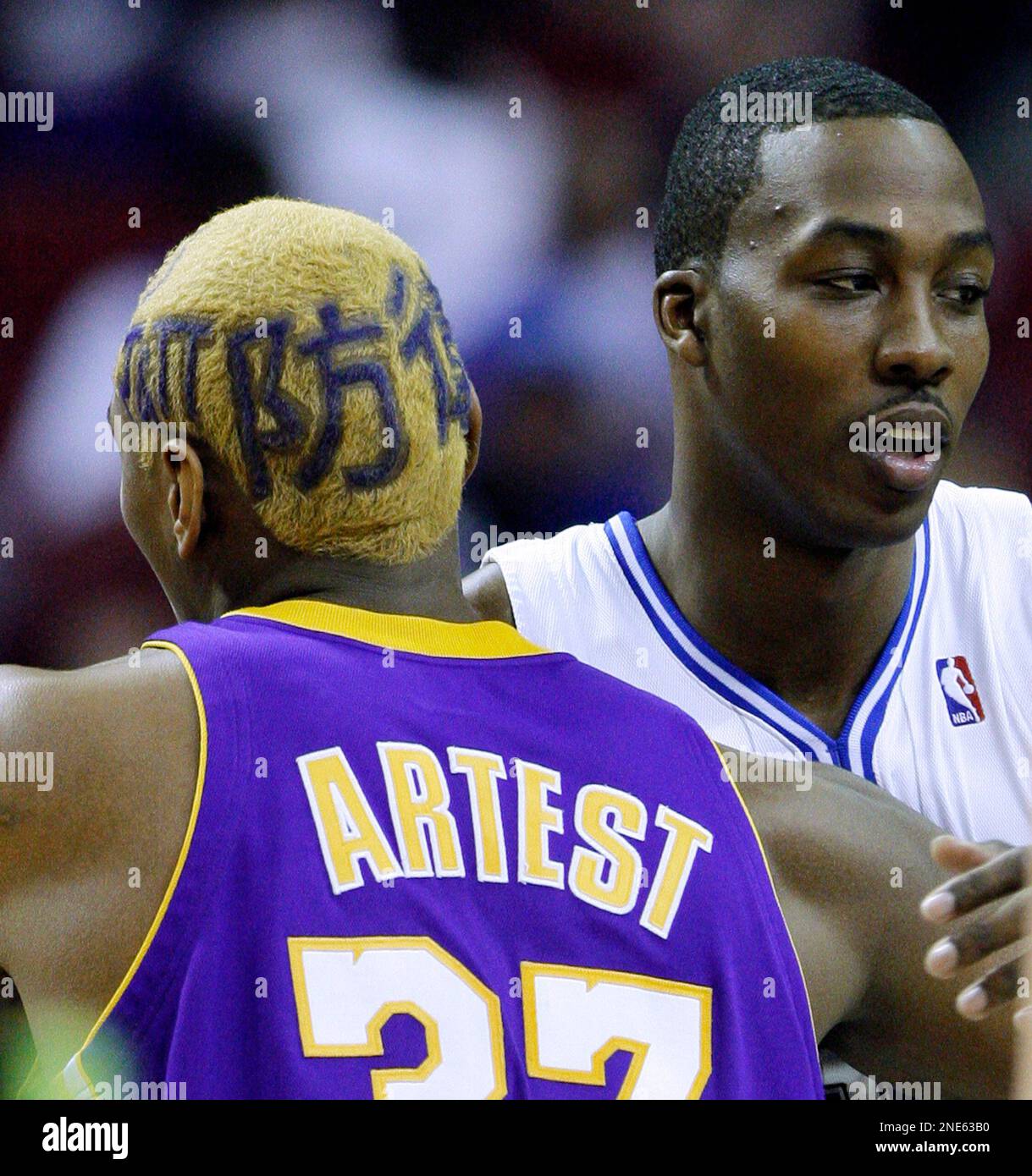 Los Angeles Lakers forward Ron Artest, left, with hair dyed blonde and  purple letters in three different languages, greets Orlando Magic center  Dwight Howard prior to the start of an NBA basketball