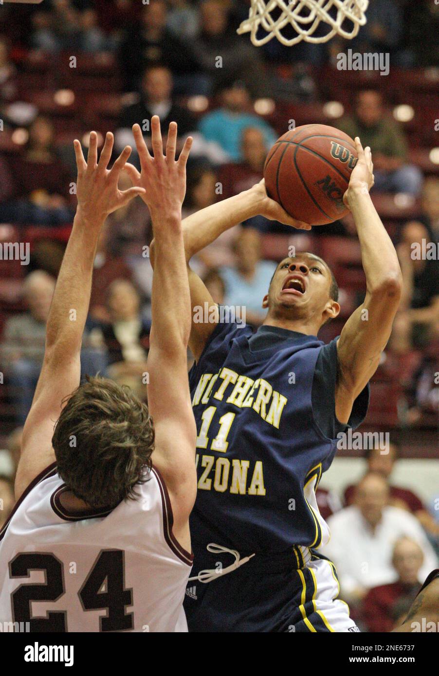 Northern Arizona guard Gabe Rogers(11) shoots in front od Montana forward Derek Selvig(24