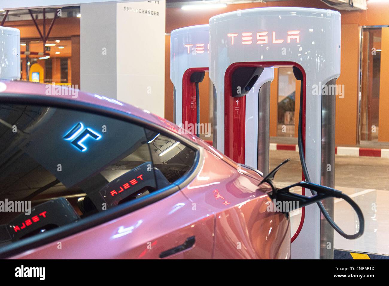 A Tesla car is seen plugged into a Tesla Supercharger at Central World
