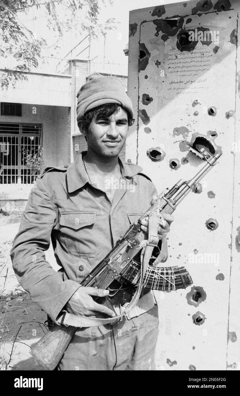 An Iraqi solider stands by the bullet-riddled door of a house in this ...