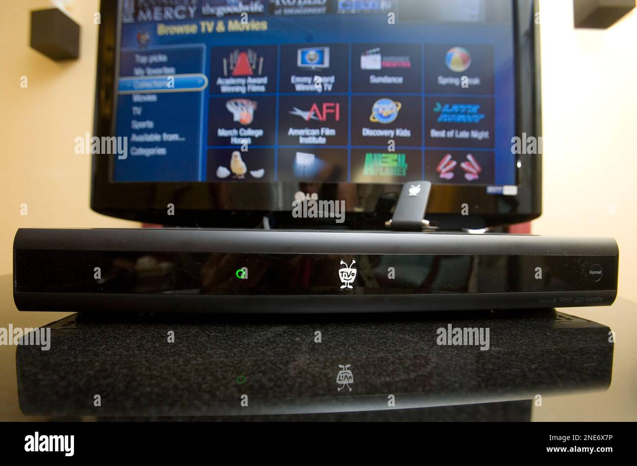 A TiVo Premiere box, foreground, is displayed with an HD television