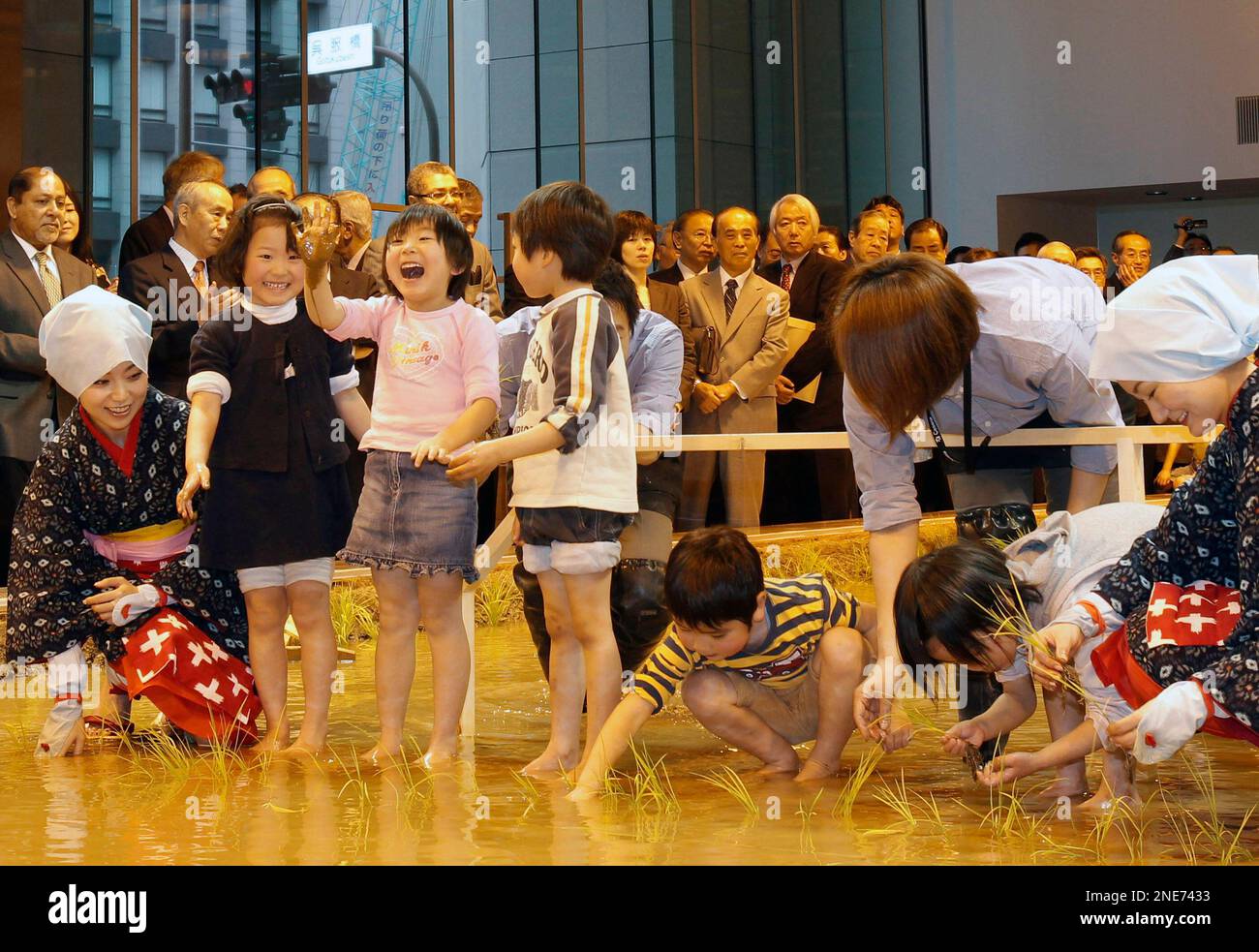 Children react as they participate in a rice planting ceremony with ...