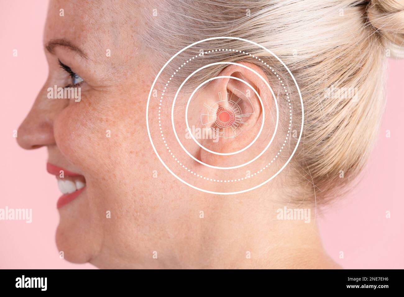 Mature woman with hearing problem on pink background, closeup Stock Photo