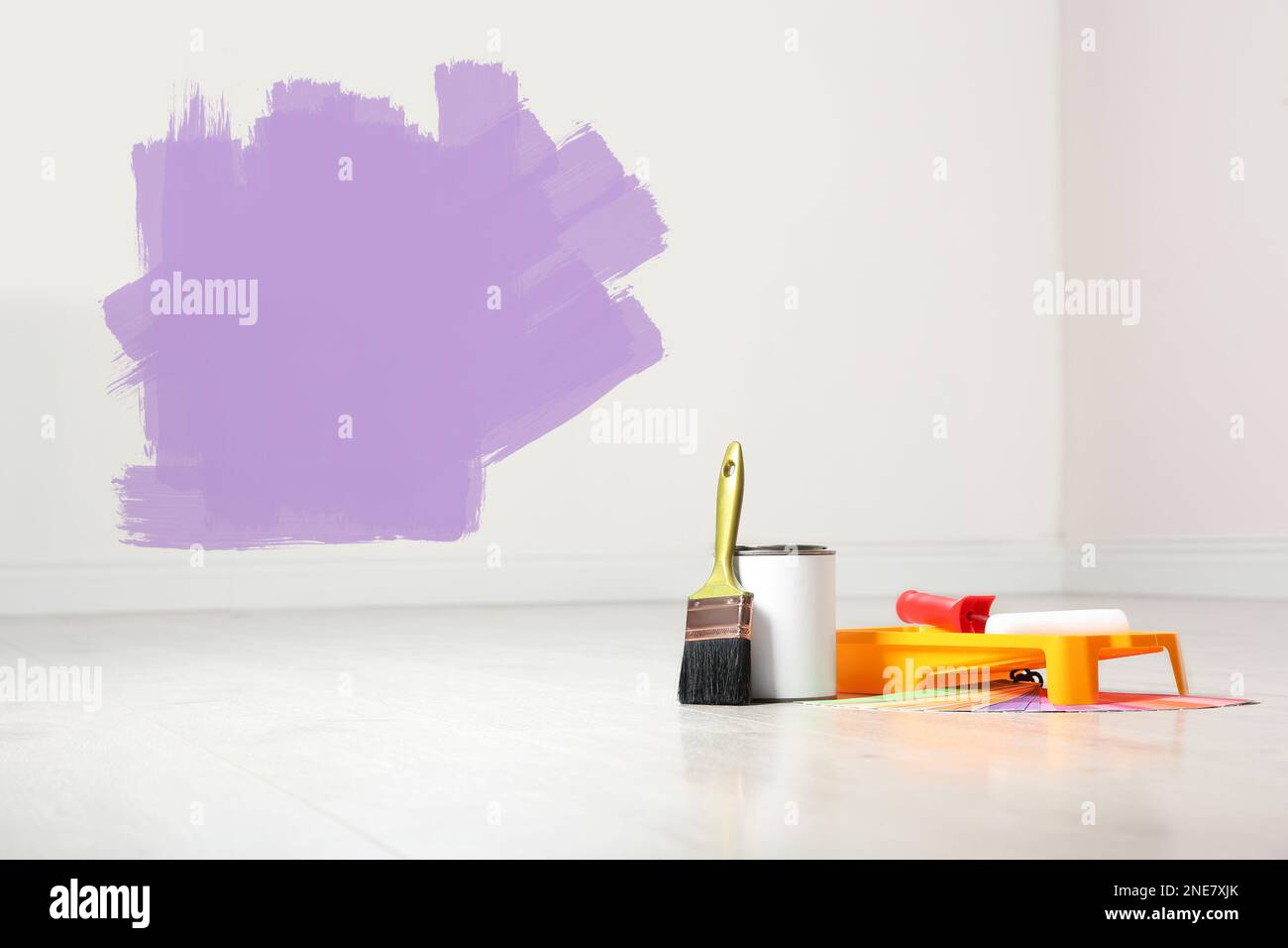 Set with decorator's tools and paint on floor near white wall Stock