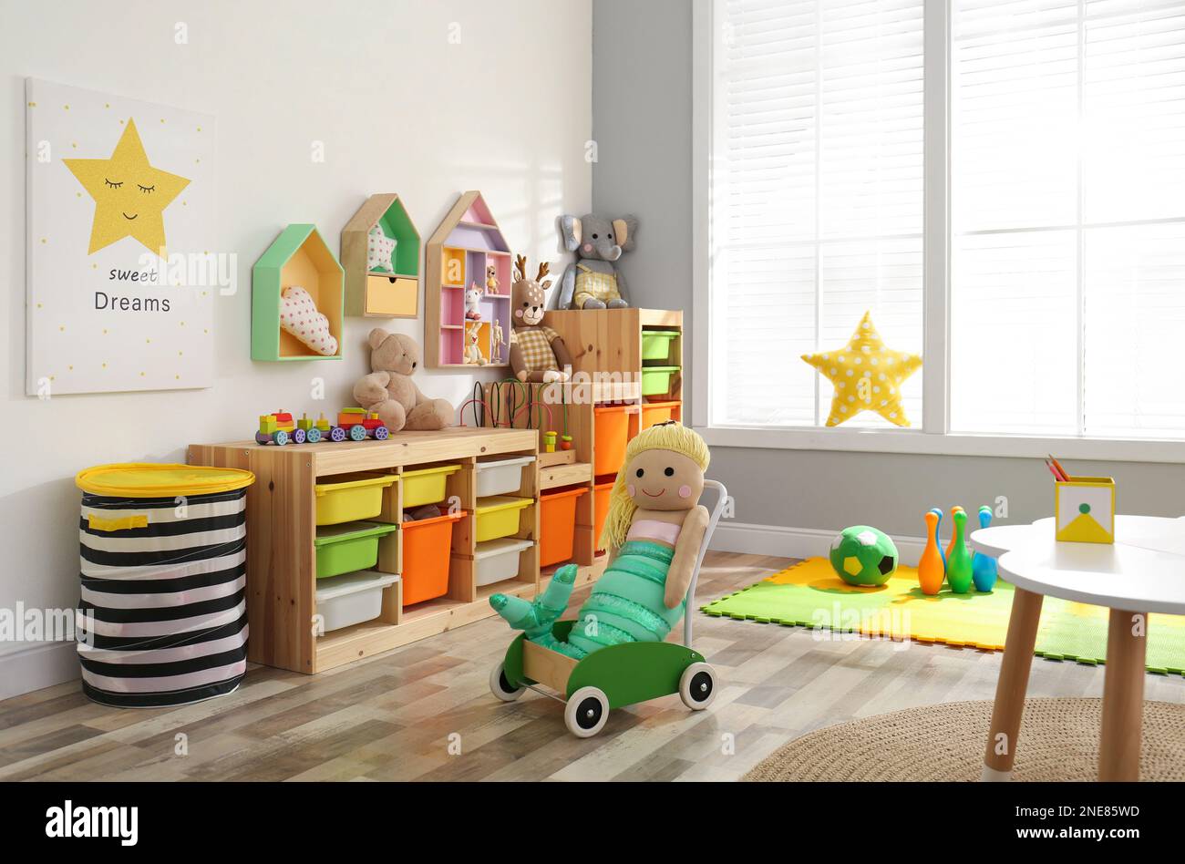 Stylish playroom interior with shelving unit and different soft toys Stock Photo