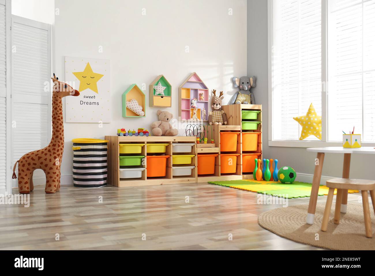 Stylish playroom interior with shelving unit and different soft toys