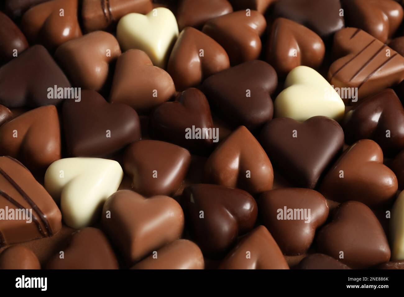 Beautiful heart shaped chocolate candies on brown background Stock