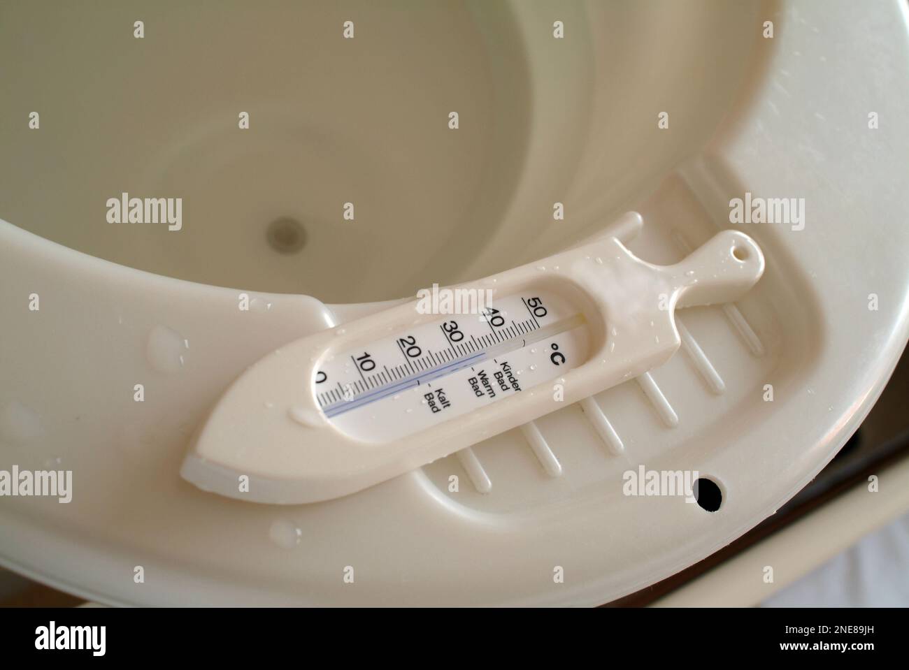 A white water thermometer on the rim of a baby bathtub Stock Photo Alamy