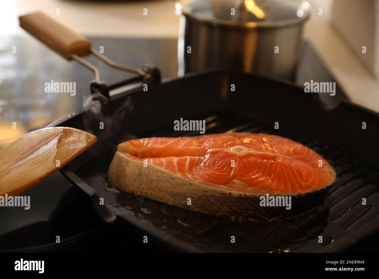Frying pan with fresh salmon steak on stove Stock Photo Alamy