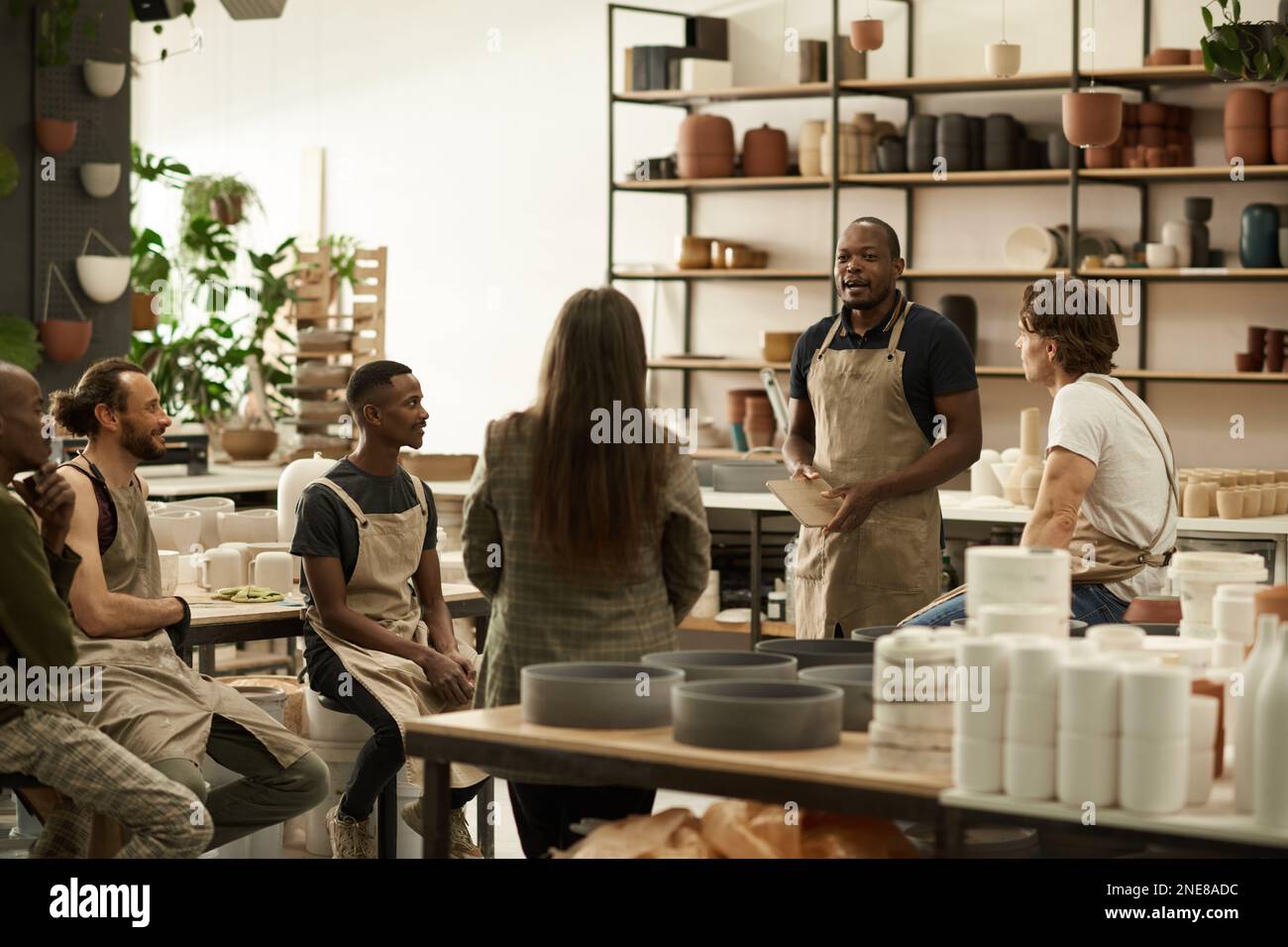 Diverse group of ceramics workers meeting together in a studio Stock ...